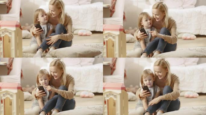 美丽的母亲和她的小女儿聊得很开心，母亲拿着智能手机。儿童房里摆满了玩具。