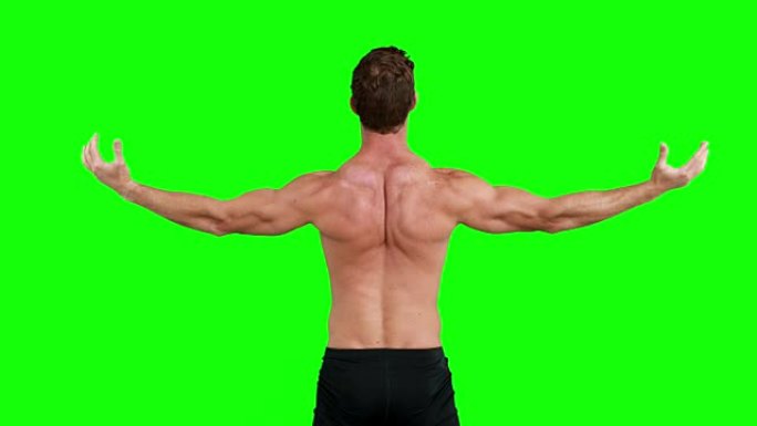 肌肉发达的人伸出双臂的后视图
