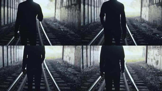 4k黑暗男子剪影在隧道中走向光明。后视图。抽象背景镜头。更好的未来。希望的概念