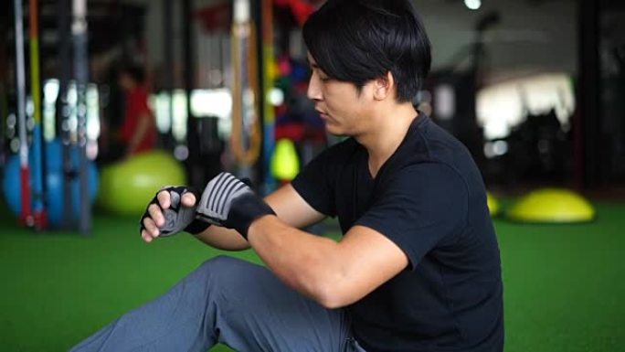 SLO MO-亚洲男子在锻炼前戴着训练手套