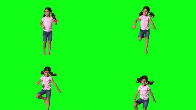 可爱的小女孩在绿色屏幕上跳跃