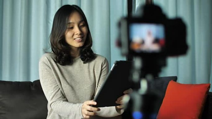 亚洲女性博客作者用相机录制视频，在家聊天