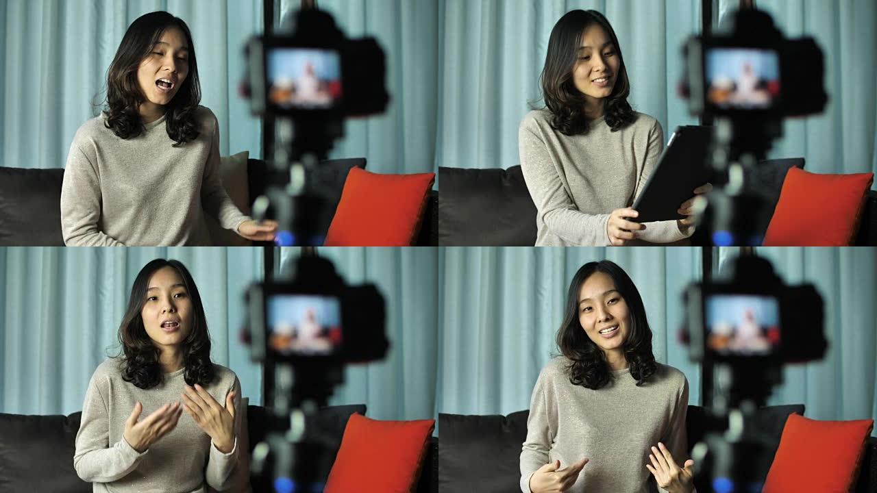 亚洲女性博客作者用相机录制视频，在家聊天