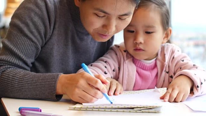 亚洲小女孩和妈妈一起做作业