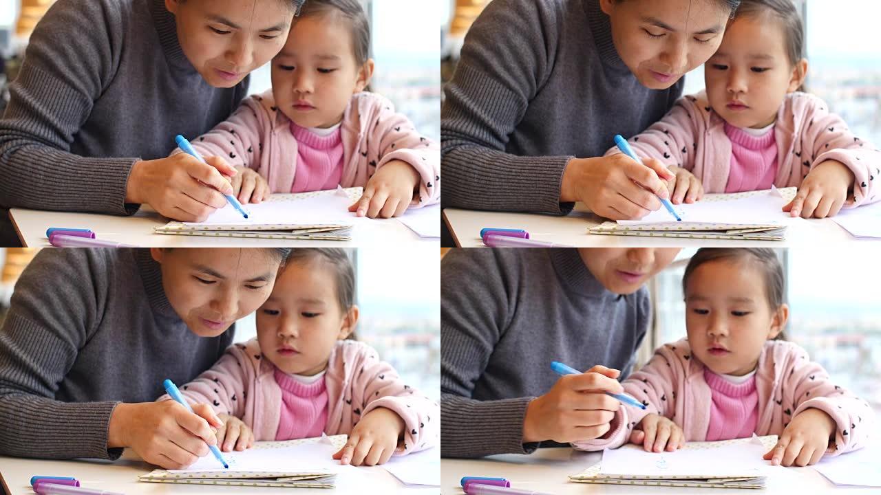 亚洲小女孩和妈妈一起做作业