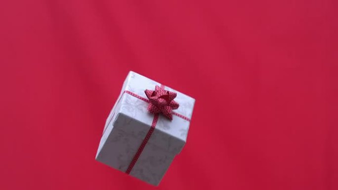 圣诞礼物在红色背景下抛向空中