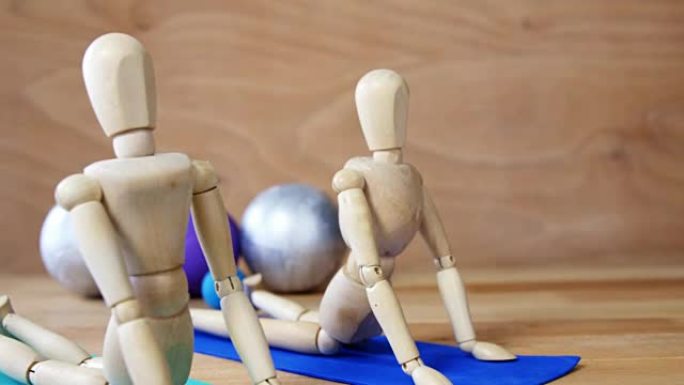 在运动垫上锻炼的木制小雕像