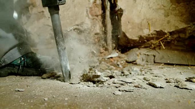 SLO MO工人使用手提钻切碎混凝土地板