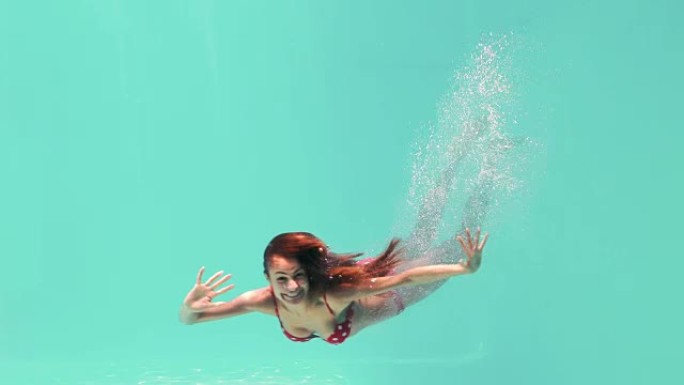微笑的女人在水下游泳