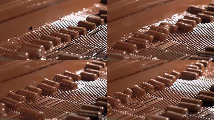 用液体巧克力倒在生产线上的糖果。
