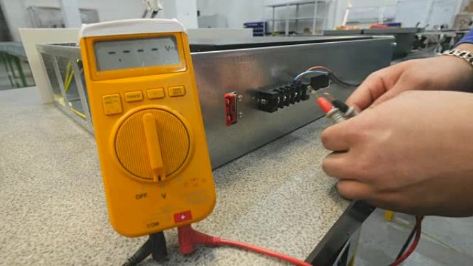 Man使用数字万用表测量电压。