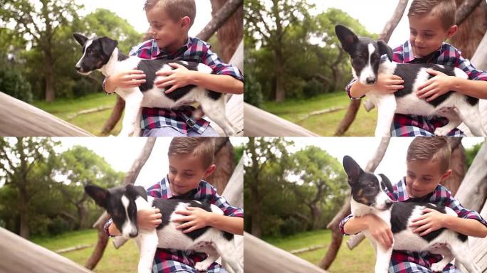 特写可爱的流氓男孩给他的小狗一个大大的拥抱