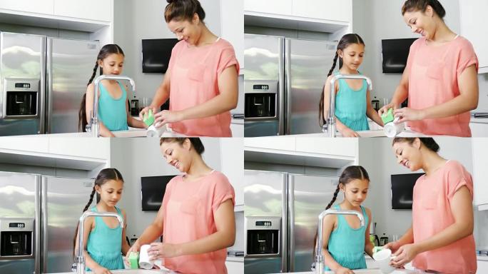 母亲教女儿在厨房洗陶器