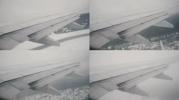 从飞机窗口到飞机机翼的视图。飞机正在跑道上飞行，在云层上飞行