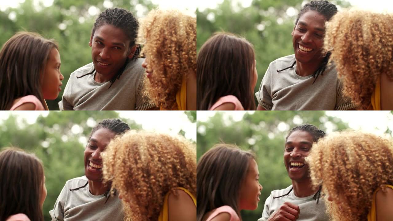 年轻的非裔美国人家庭与可爱的女儿一起笑着微笑