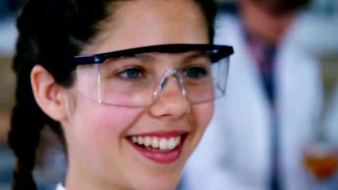 微笑的女学生在实验室做化学实验