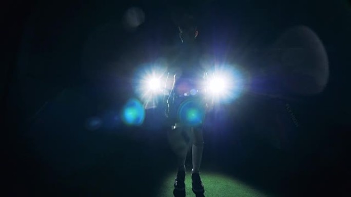 职业足球运动员在明亮的灯光下耍球，正面，特写。