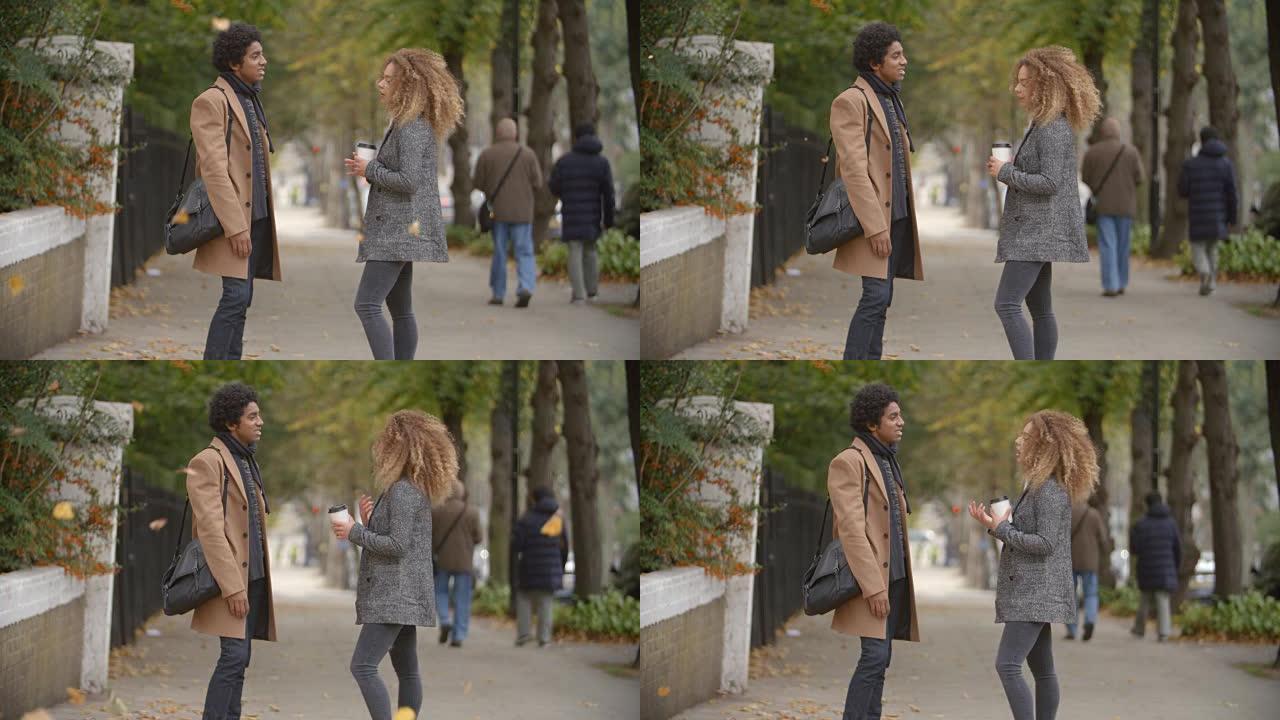 时尚的年轻夫妇在城市的秋天街上聊天