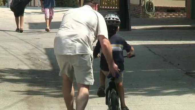 HD：小孩与父亲一起学习骑自行车