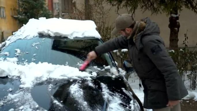 男子从汽车上除雪