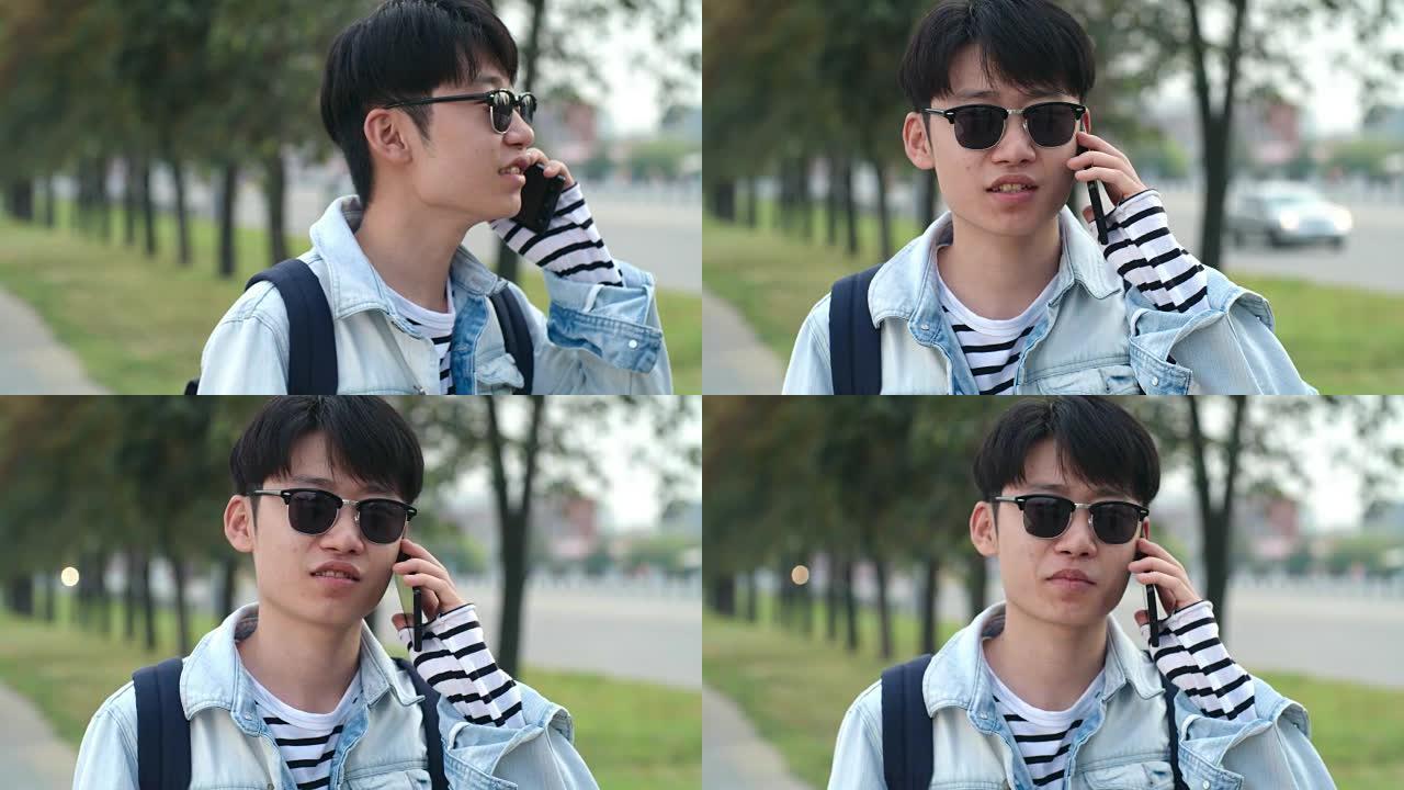 十几岁的亚洲男孩在街上用手机聊天