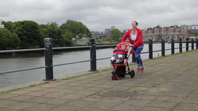 母亲带着婴儿在河边的马车里奔跑