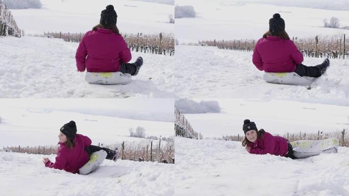 4k微笑的女孩在白雪皑皑的葡萄园里雪橇，慢动作