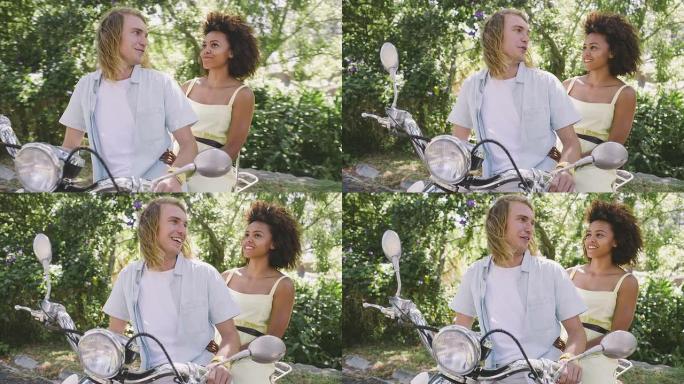 年轻的快乐夫妇坐在踏板车上