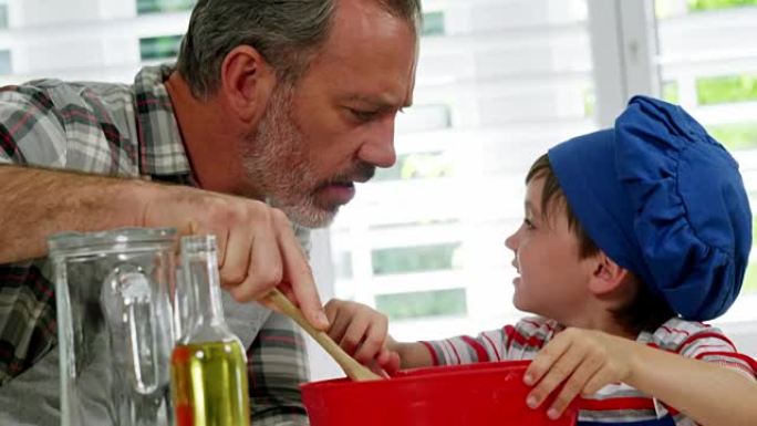 父亲和男孩在碗中搅拌面团