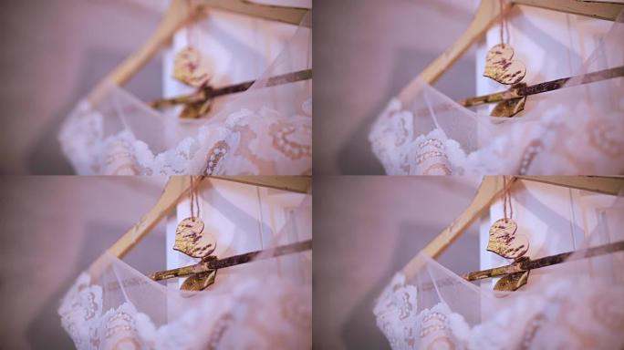 漂亮的白色婚纱挂在卧室的衣架上。新娘的早晨准备，乡村风格的细节