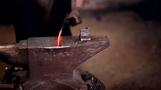 铁匠用铁锤在铁炉铁砧上工作。工作场所的特写视图