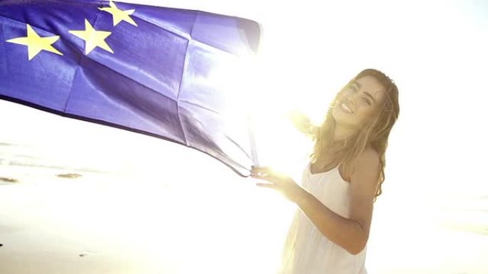 快乐的女人挥舞着欧洲国旗，对着镜头微笑