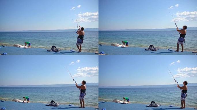 4k男子在阳光明媚的海洋海滩上准备风筝冲浪设备，实时