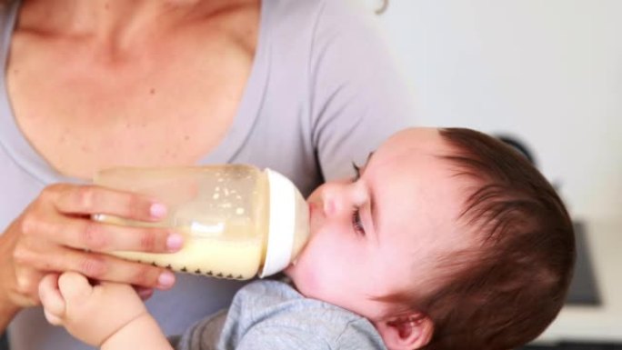 快乐的母亲给她的男婴喂奶瓶