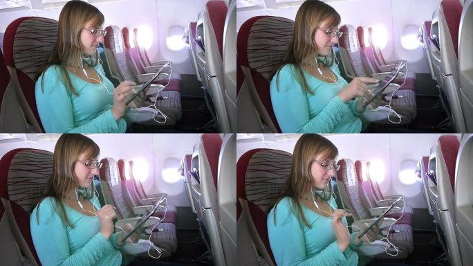 使用数字平板电脑并在飞机上听音乐的女人