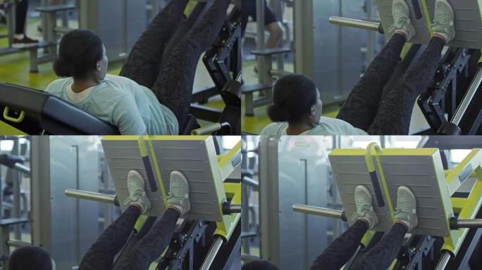 在健身房使用压腿机的女人