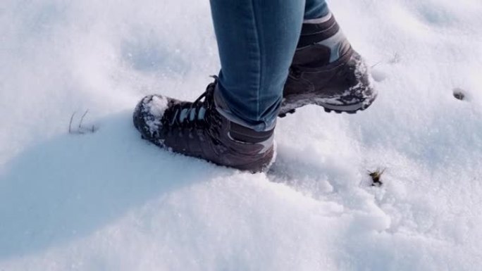 穿着靴子的徒步旅行者在雪地里行走，超级慢动作