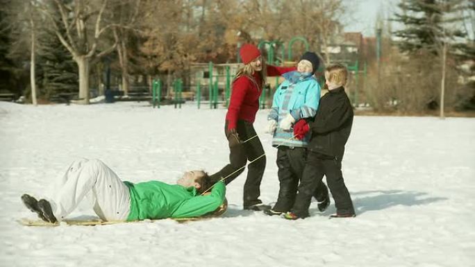 一家人把爸爸拉上雪橇