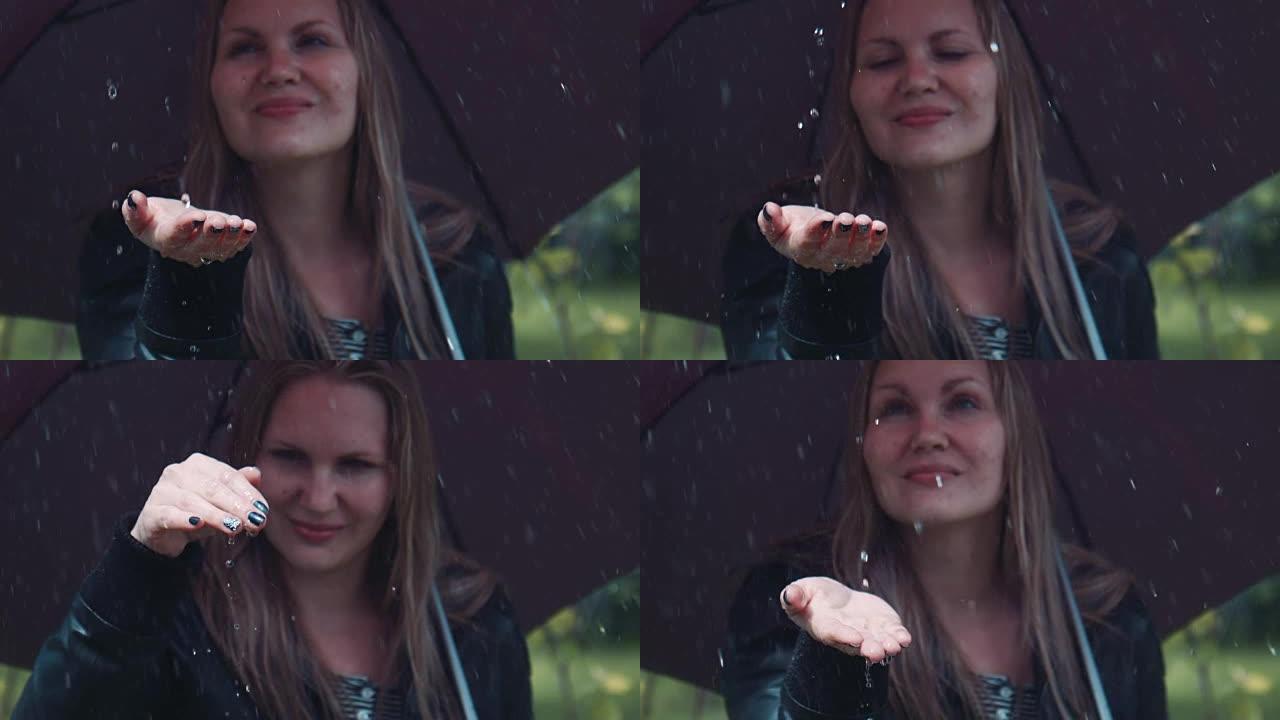 金发女人在黑色扭动伞下享受雨水