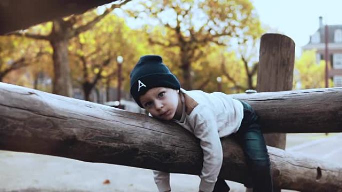 可爱的小男孩在冒险公园玩得开心。困惑的紧张孩子戴着帽子犹豫不决，被困在绳索上障碍