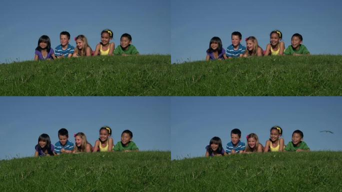 一群孩子躺在长满青草的小山上