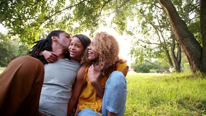 年轻的非裔美国人家庭与可爱的女儿一起笑着微笑
