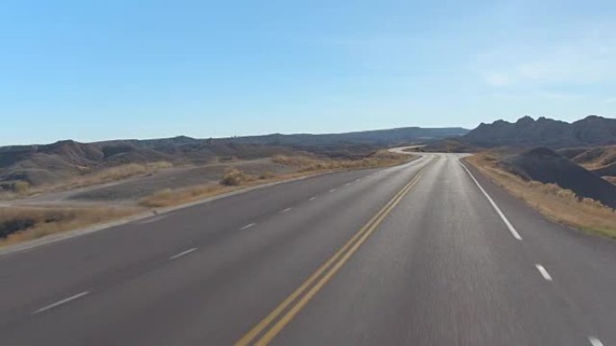 FPV: 沿着空荡荡的道路蜿蜒穿过荒地山区沙漠
