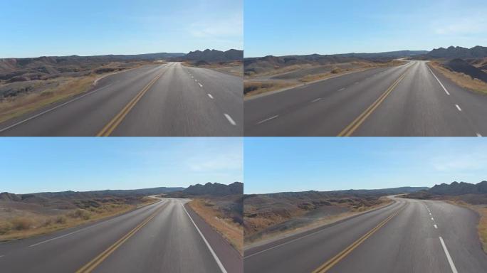 FPV: 沿着空荡荡的道路蜿蜒穿过荒地山区沙漠