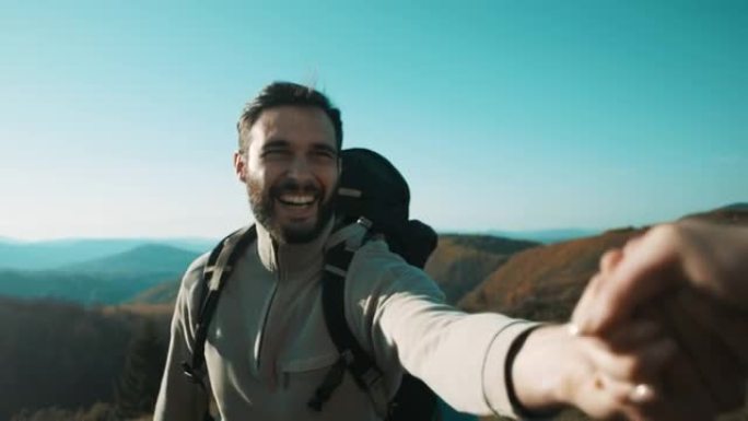 男人牵着女人的手在山上