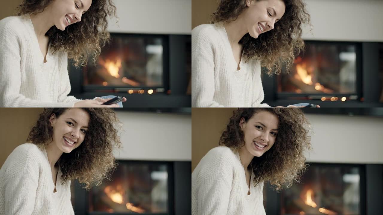 女人坐在壁炉前使用电话