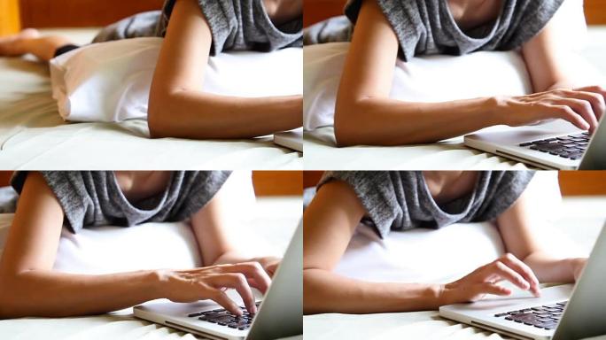年轻的西班牙裔妇女在床上使用笔记本电脑。绿屏。平移风格。