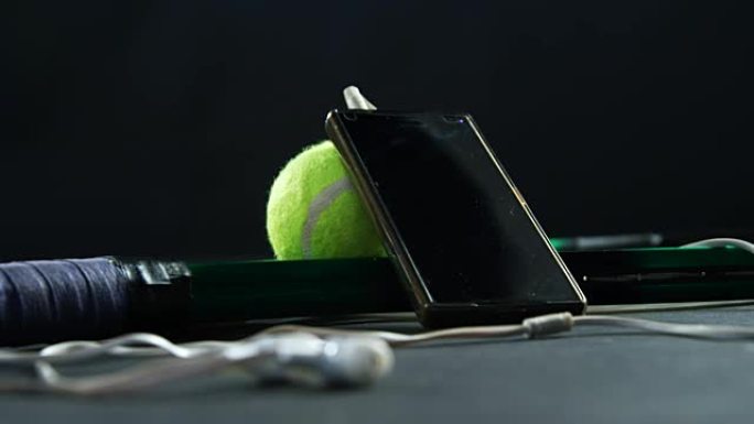 studio 4k带耳机的网球、球拍和手机