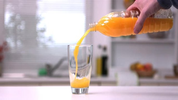 男人手倒橙汁