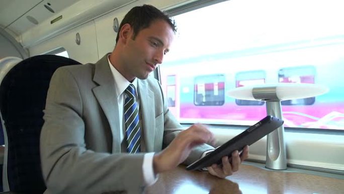 使用数字平板电脑在火车上通勤的商人